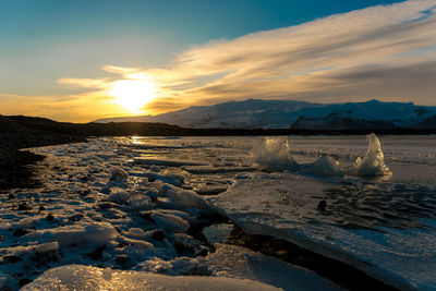 Scenic view of frozen sea against sky during sunset