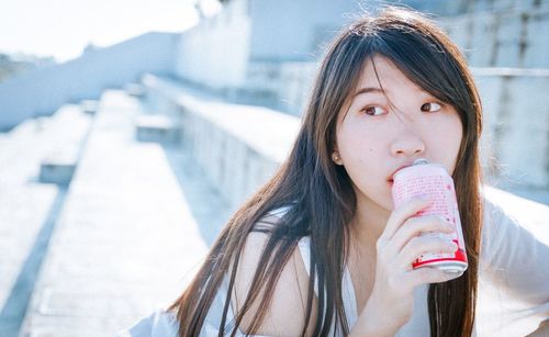 Portrait of young woman drinking food