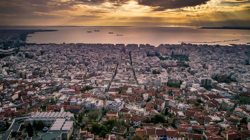 Aerial view of town by sea against sky