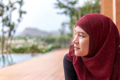 Woman in red hijab looking away outdoors