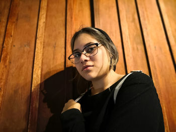 Portrait of girl against wooden wall