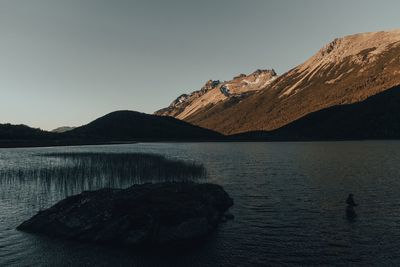 Scenic view of lake and mountains against clear sky