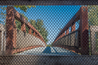 Close-up of basketball hoop seen through chainlink fence