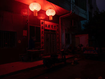 Illuminated lanterns by building in city at night