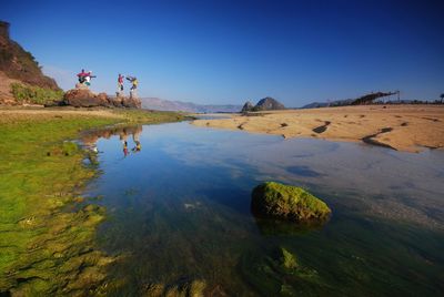 Scenic view of rocks against clear blue sky