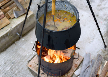 High angle close-up photo of stew cooking in cast iron pot over fire