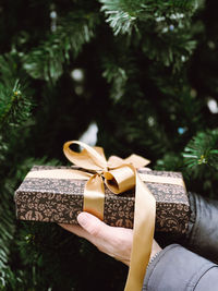 Woman holding wrapped christmas gift .