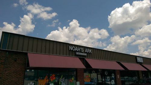 Low angle view of information sign against sky