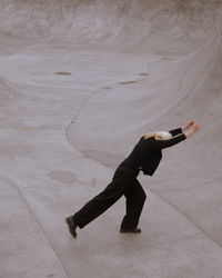 One woman in black performing the grey concrete pool 