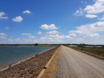 Road amidst land against sky