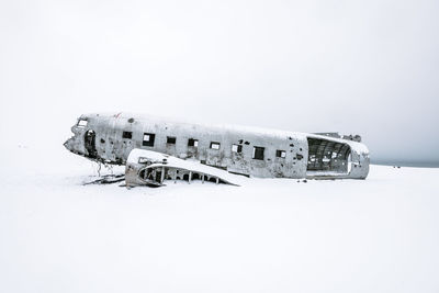 Abandoned airplane against clear sky during winter