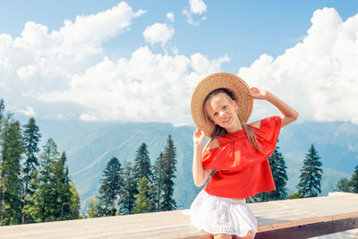 Portrait of woman standing against mountain