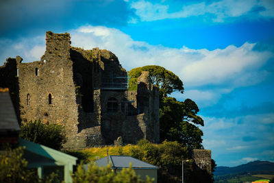 Low angle view of old ruin building against cloudy sky