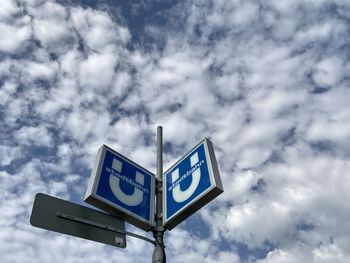 Low angle view of road sign against sky