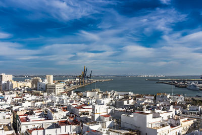 High angle view of buildings by sea against sky