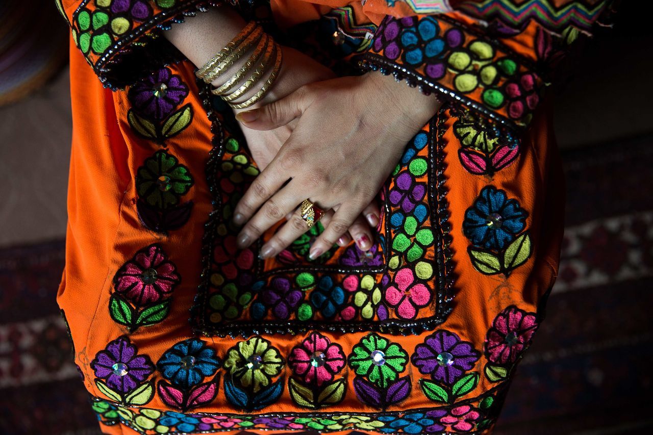one person, human hand, multi colored, human body part, hand, pattern, midsection, adult, floral pattern, body part, bracelet, art and craft, focus on foreground, women, jewelry, close-up, real people, indoors, clothing, finger