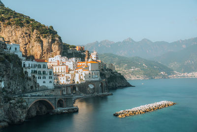 Scenic view of sea and mountains against clear sky