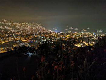 High angle view of illuminated city against sky at night