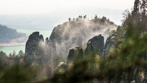 Panoramic view of rocks and trees against sky