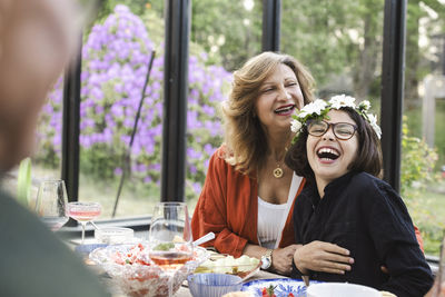 Cheerful grandmother and grandson enjoying midsummer party at patio