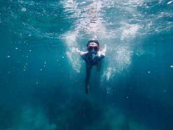 Portrait of young woman scuba diving in sea