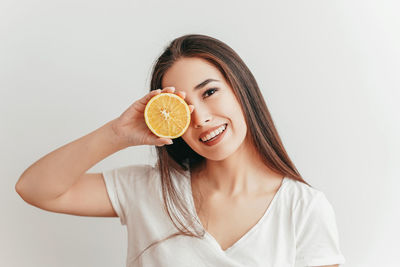 Portrait of a smiling young woman against white background