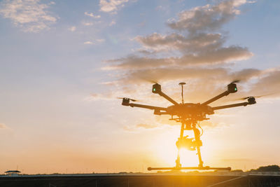 Low angle view of airplane against sky during sunset