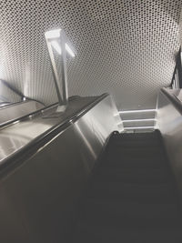 Low angle view of illuminated escalator in building