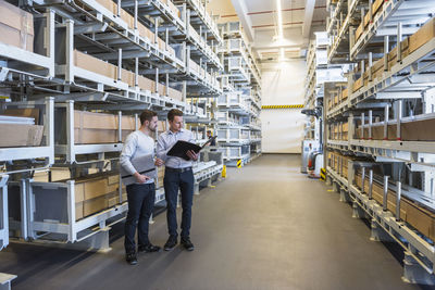 Two men talking in factory warehouse