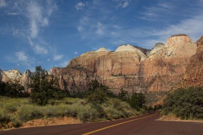 Road by rock formations against sky