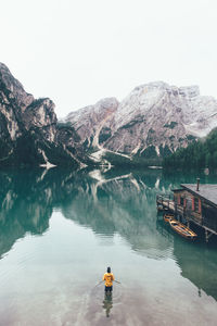 Rear view of man standing in pragser wildsee against dolomites