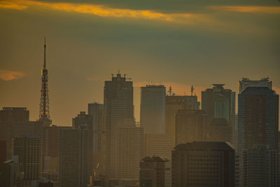 Buildings in city against sky during sunset