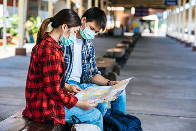 Rear view of friends looking at camera