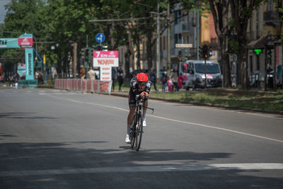 Man riding bicycle on road in city