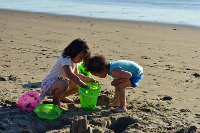 High angle view of boy playing with sand at beach