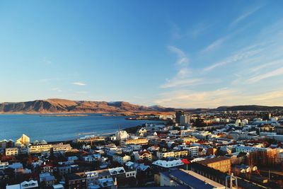 High angle view of city by sea against sky