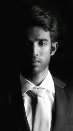 Portrait of young man against black background