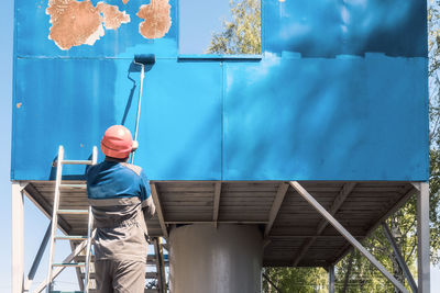 Low angle view of man standing against wall