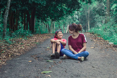 Woman and boy sitting on road