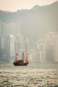 Ship in sea against buildings in city