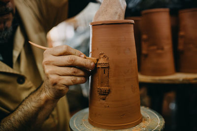 Midsection of man working in pottery workshop