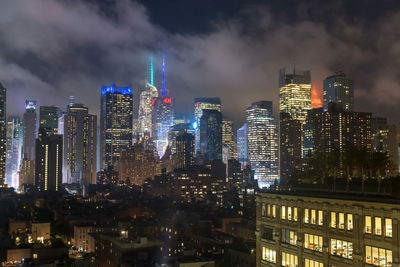 Illuminated buildings in city against sky at night