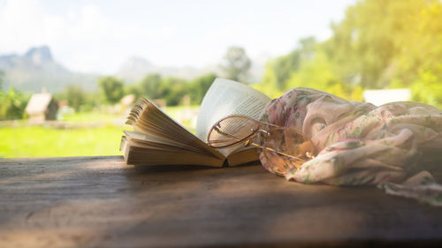 Close-up of open book on table against sky