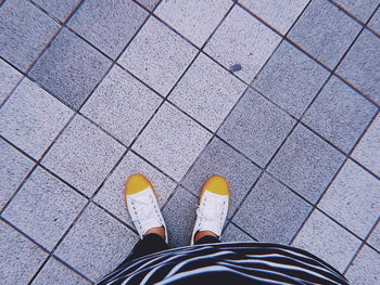 Low section of woman standing on tiled floor