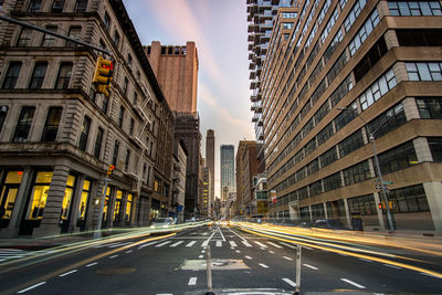 Road amidst buildings in city against sky