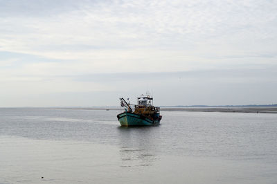 Boat sailing on sea against sky