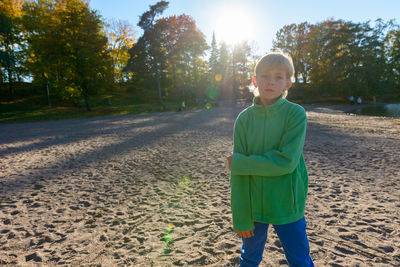 Portrait of boy standing against trees