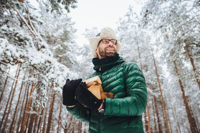 Portrait of young man standing in snow