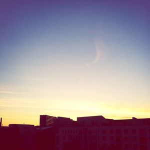 Low angle view of buildings against sky at sunset