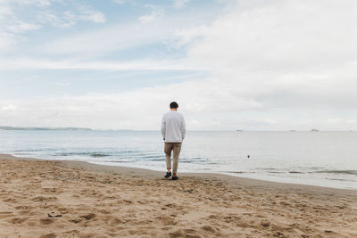 Rear view of man standing on beach